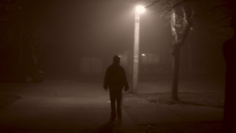 person walking on foggy street