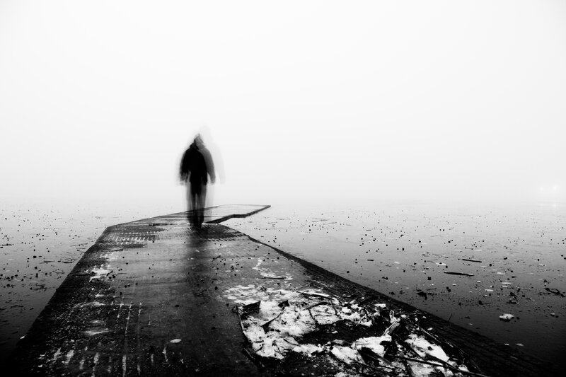 person walking on pier in fog