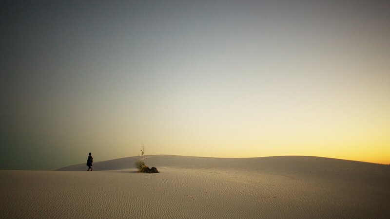 Person Walking on Sand Dunes — White, Serene