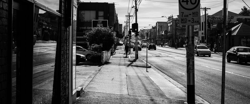 Person Walking on Sidewalk — Black, Dramatic, Afternoon