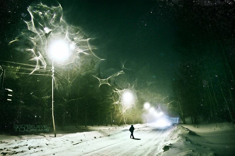 person walking on snowy road at night