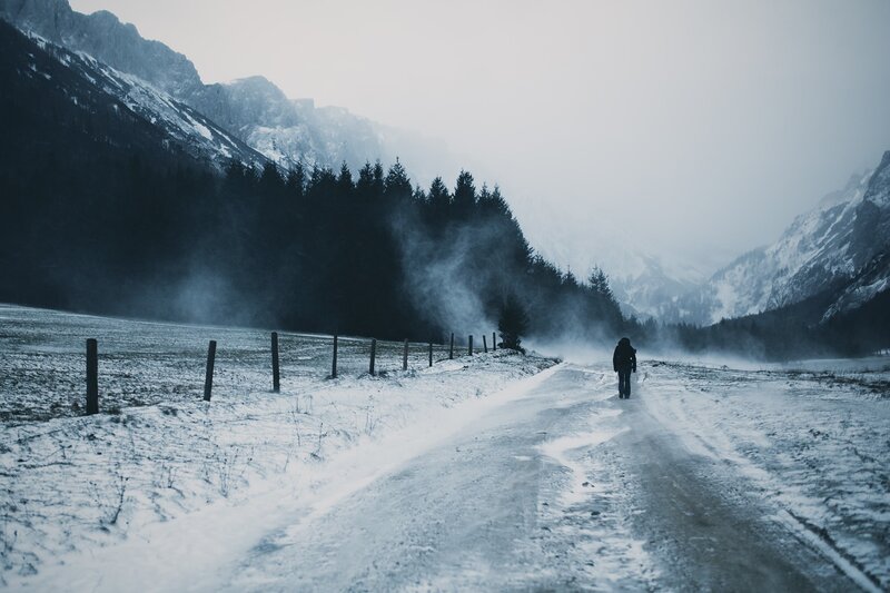 Person Walking on Snowy Road — Blue