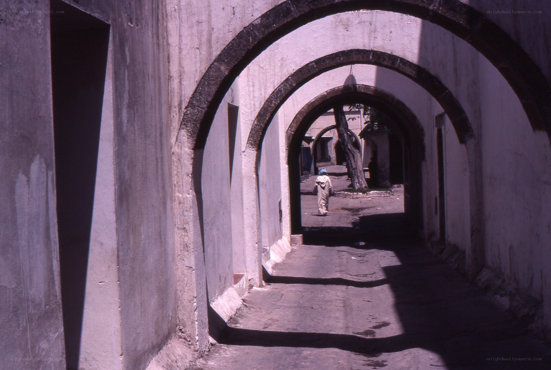 Person walking through arched corridor
