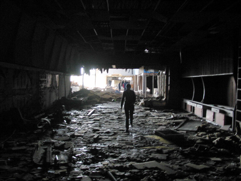 Person walking through damaged building