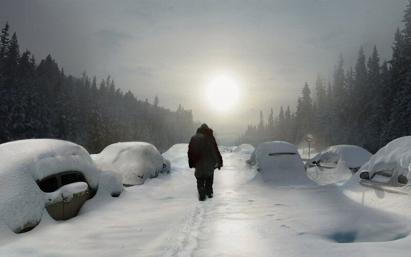 person walking through snow-covered parking lot