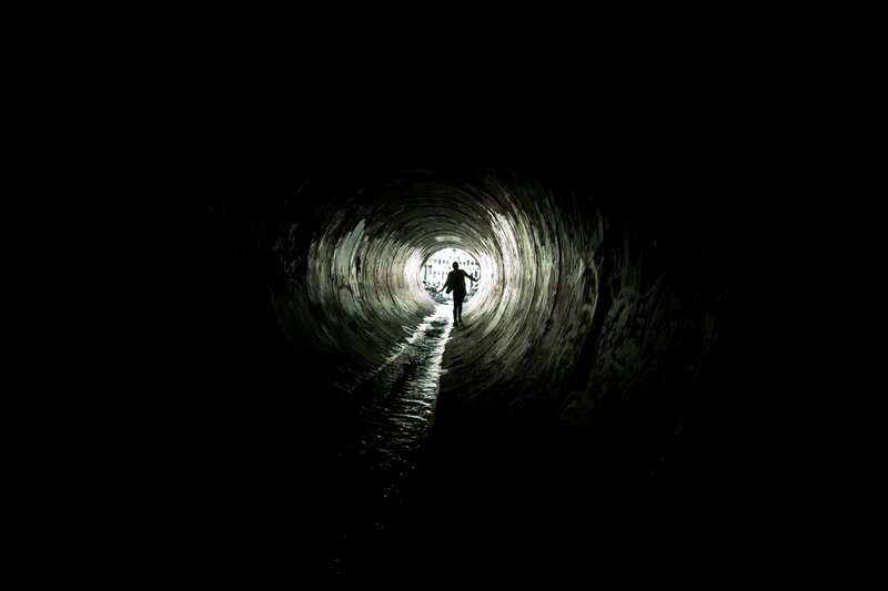 person walking through tunnel