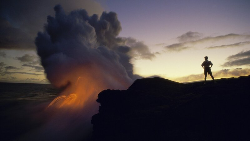 Person watching lava flow into ocean