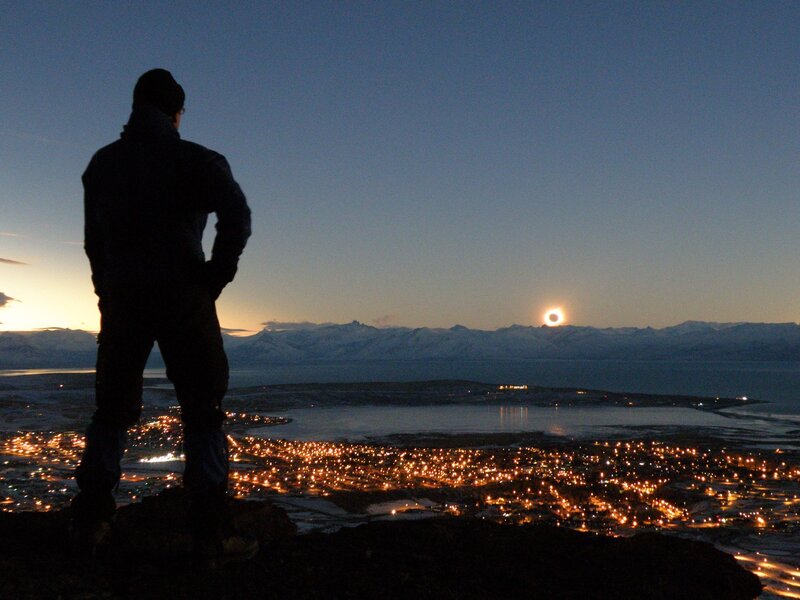 person watching moonrise over city
