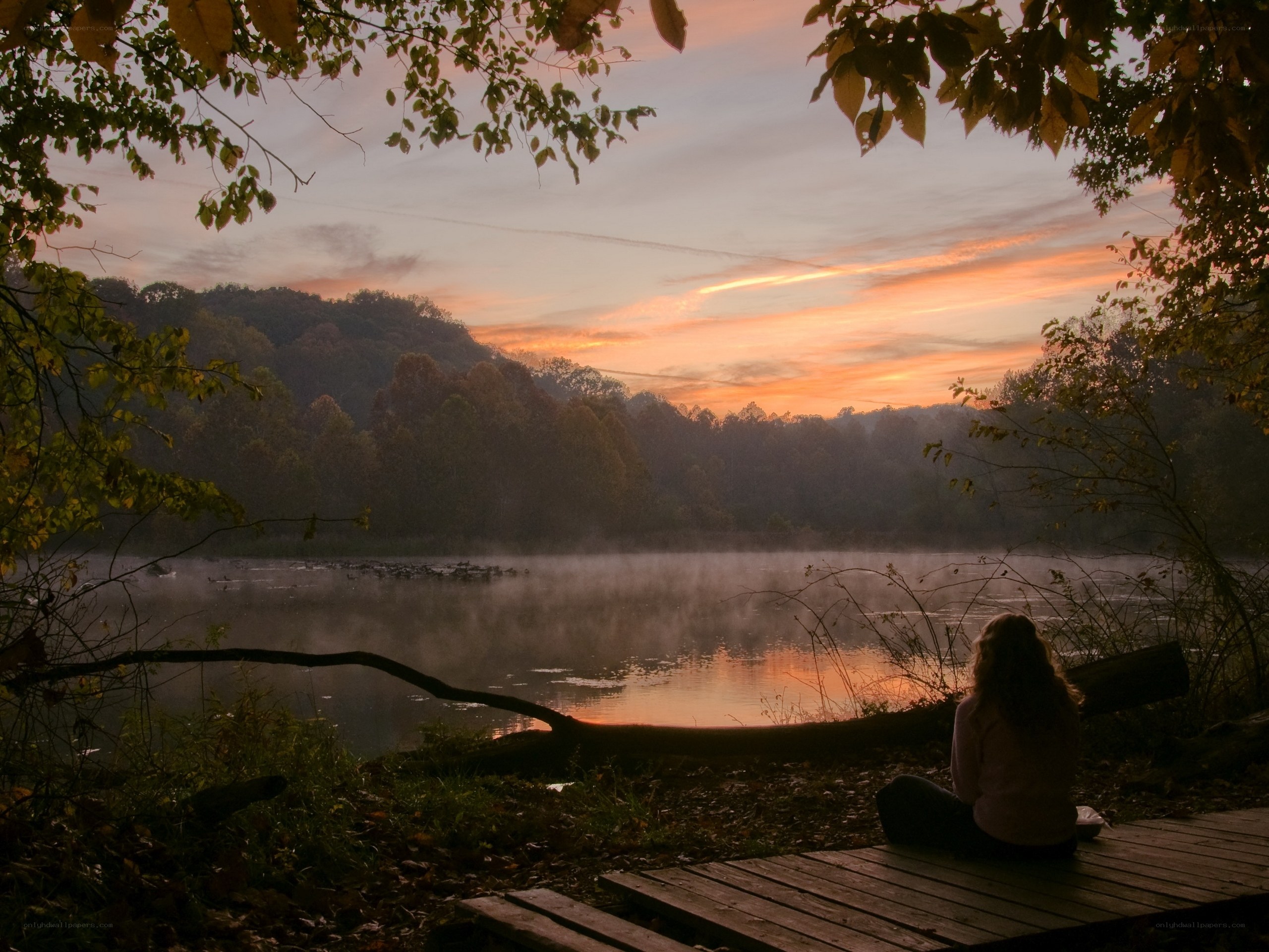 Person watching sunset by a lake