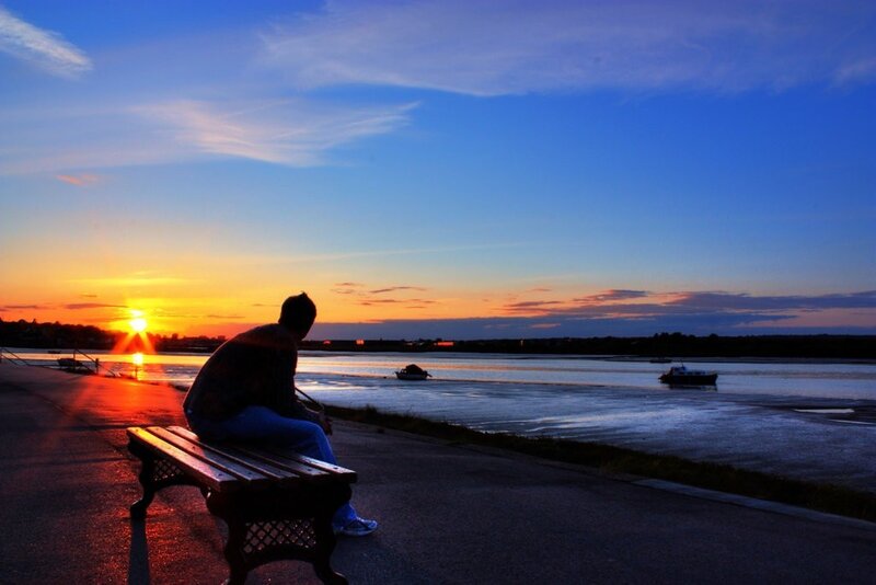 Person watching sunset by the water