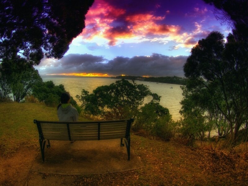 Person watching sunset by the water