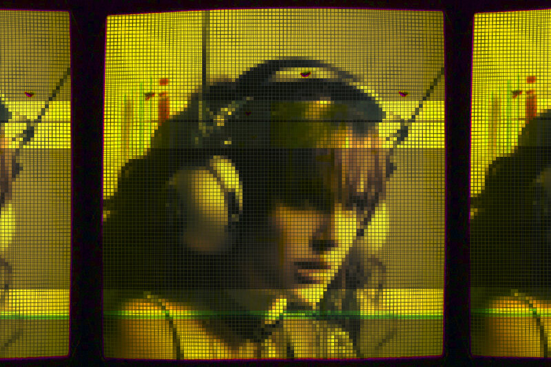 person wearing headphones behind mesh