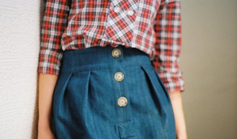 person wearing plaid shirt and denim skirt