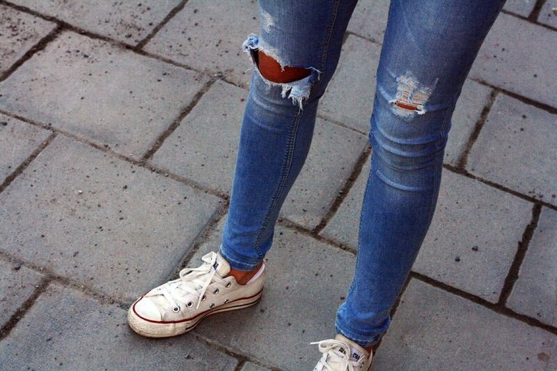 person wearing ripped jeans