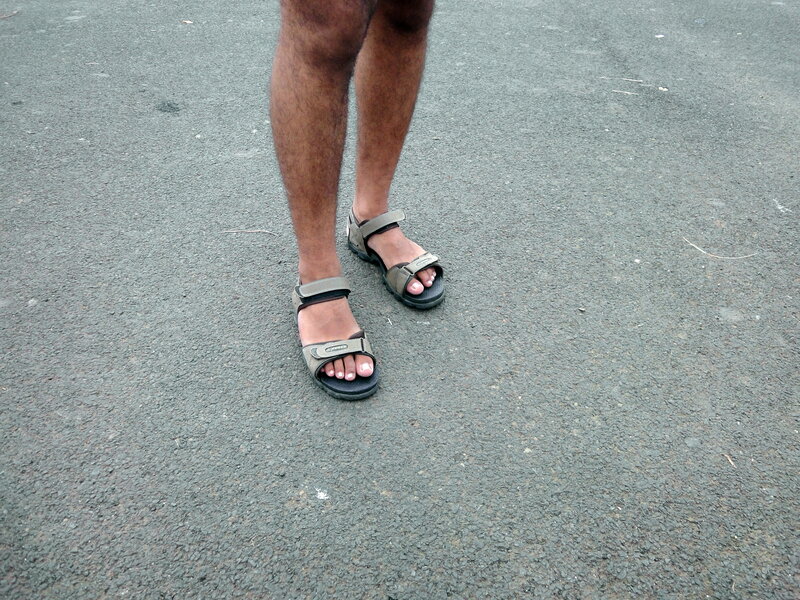 person wearing sandals on pavement