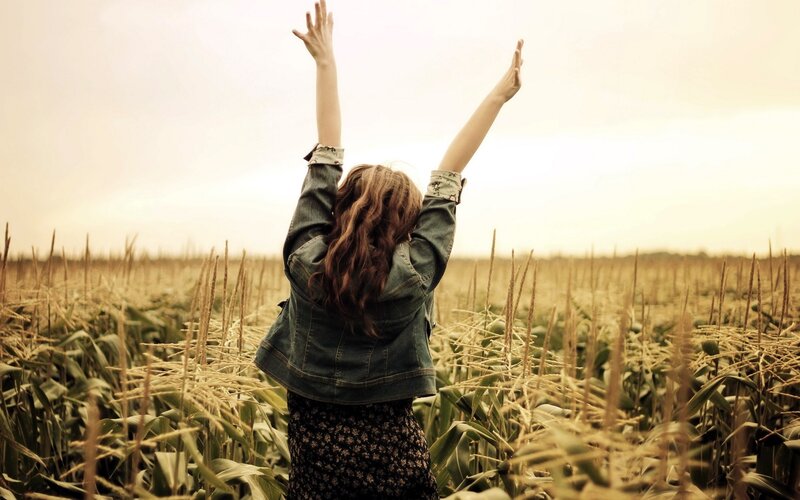 person with arms raised in field