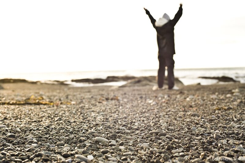 Person with arms raised on beach