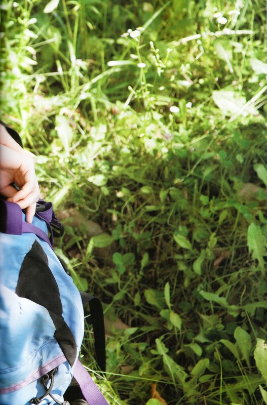 person with backpack in grass