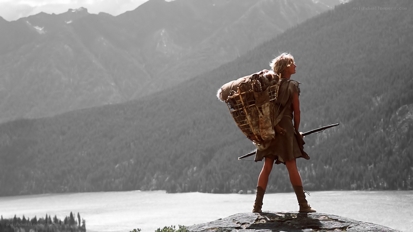 person with backpack on cliff