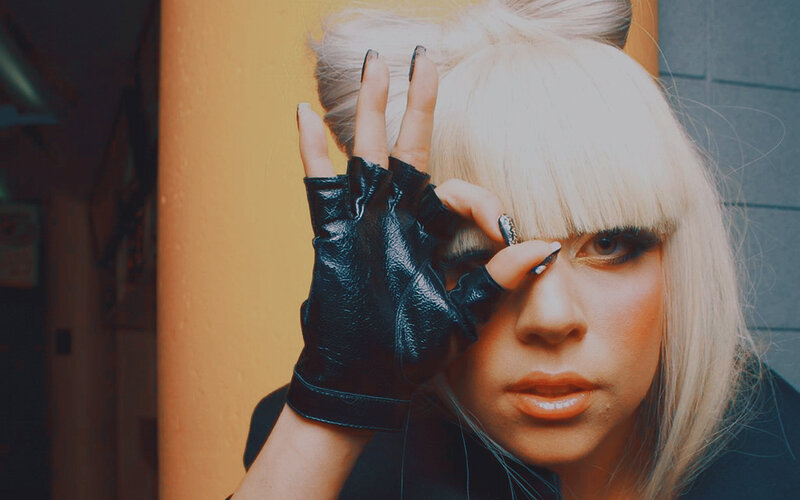 person with blonde hair and black glove