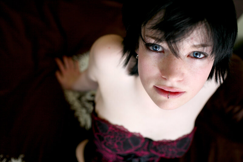 person with blue eyes and lip piercing