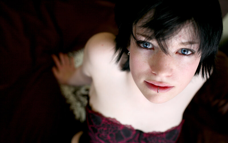 person with blue eyes and lip piercing