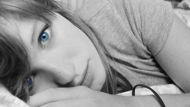 person with blue eyes lying down