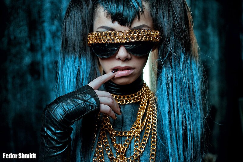 person with blue hair and gold chains