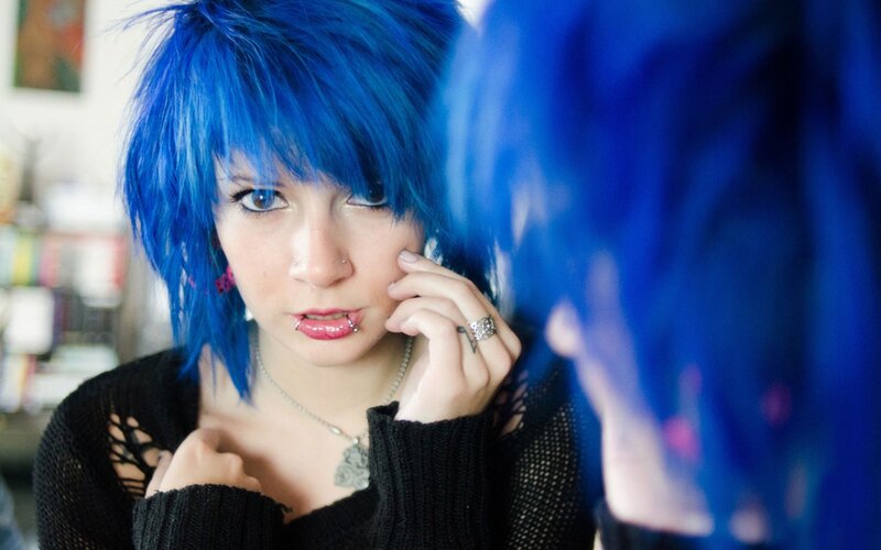 person with blue hair looking in mirror