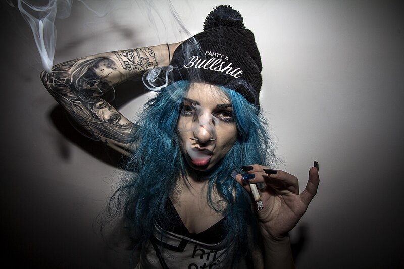person with blue hair smoking