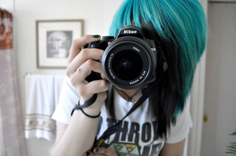 person with blue hair taking a mirror selfie