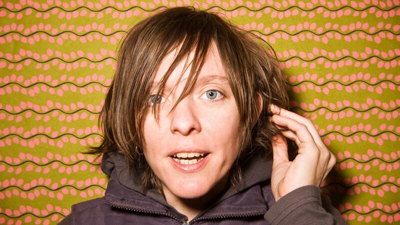 person with brown hair against patterned wall