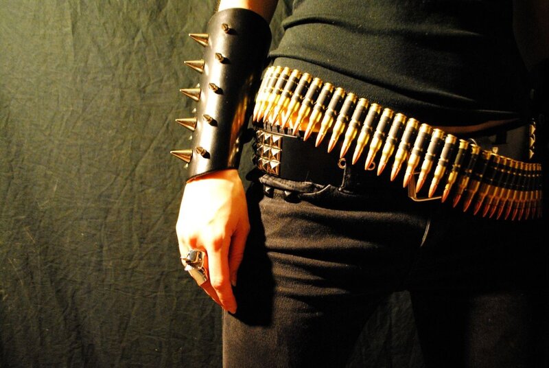 person with bullet belt and spiked arm guard