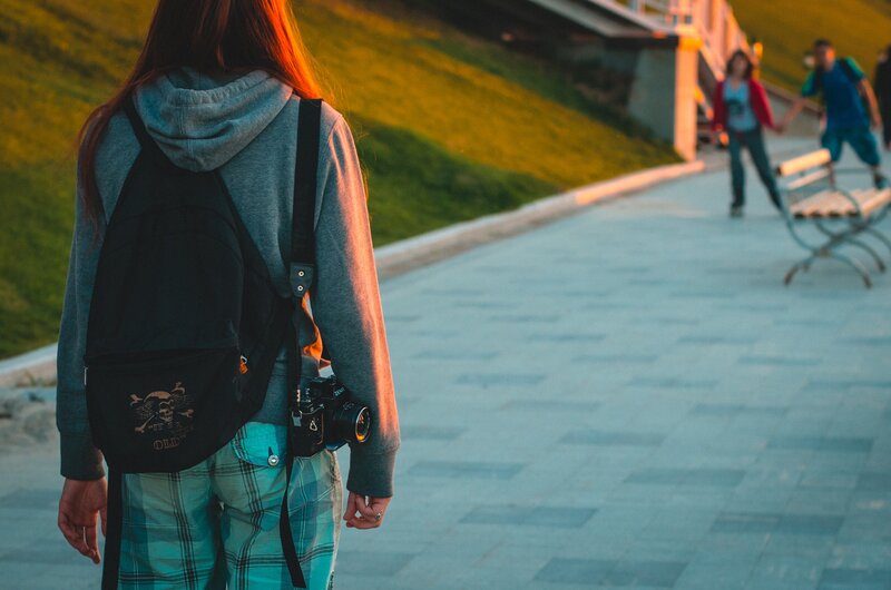 Person with camera walking at sunset
