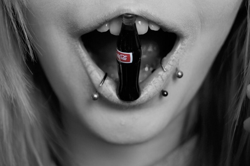 person with Coca-Cola bottle in mouth