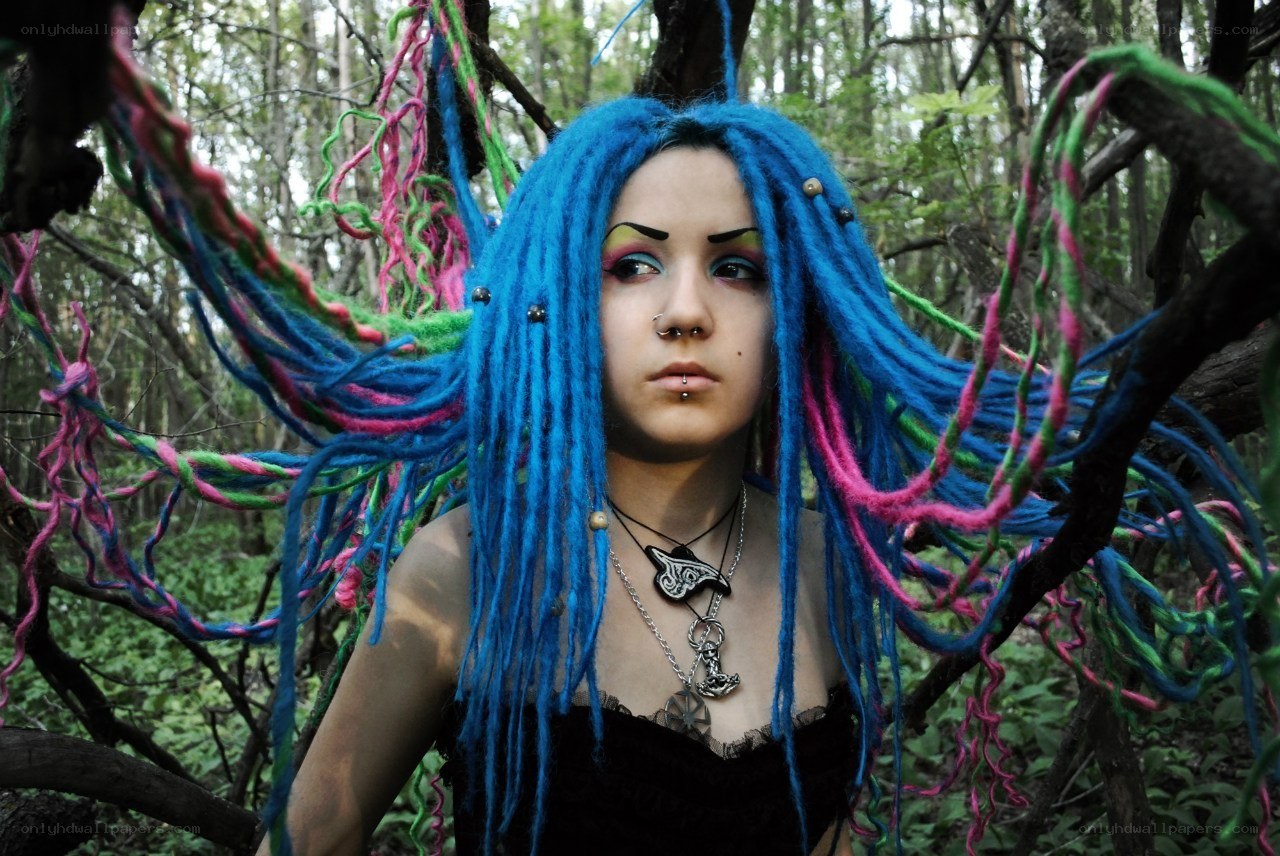person with colorful dreadlocks in forest