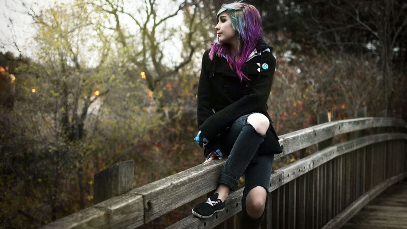 person with colorful hair on bridge