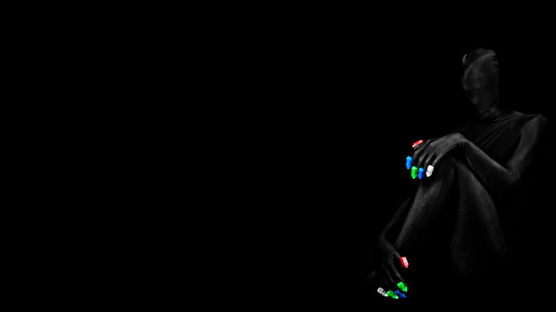 person with colorful nails in dark room