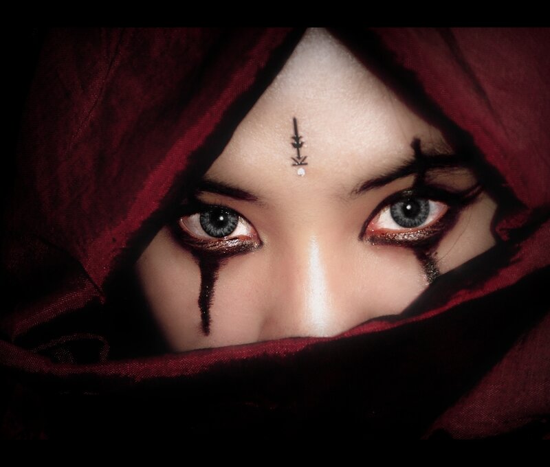 person with dark makeup and red hood