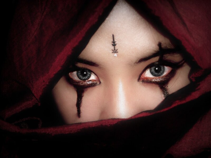 person with dark makeup and red hood