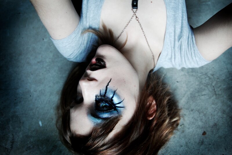 person with dramatic makeup lying down
