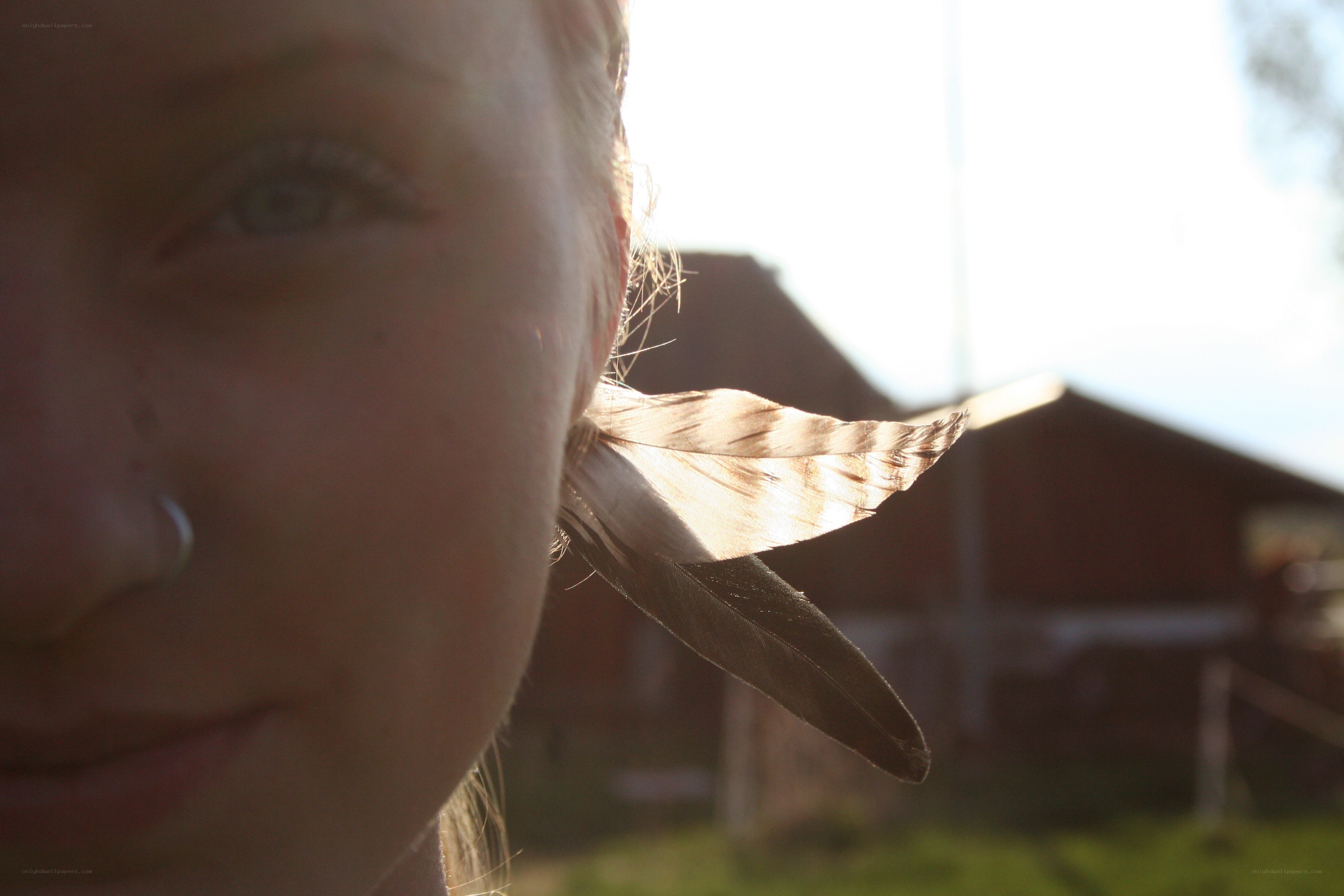 person with feather in ear