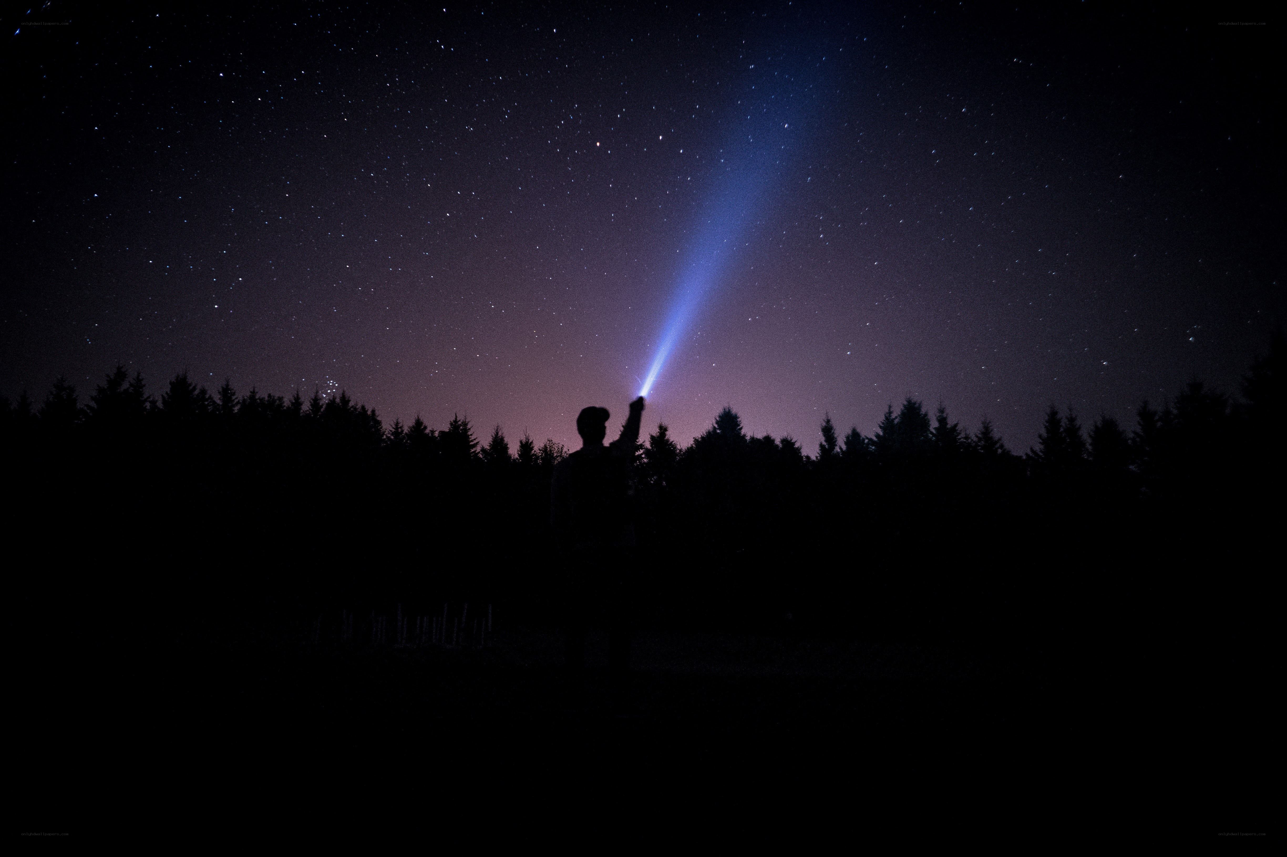 Person with flashlight at night