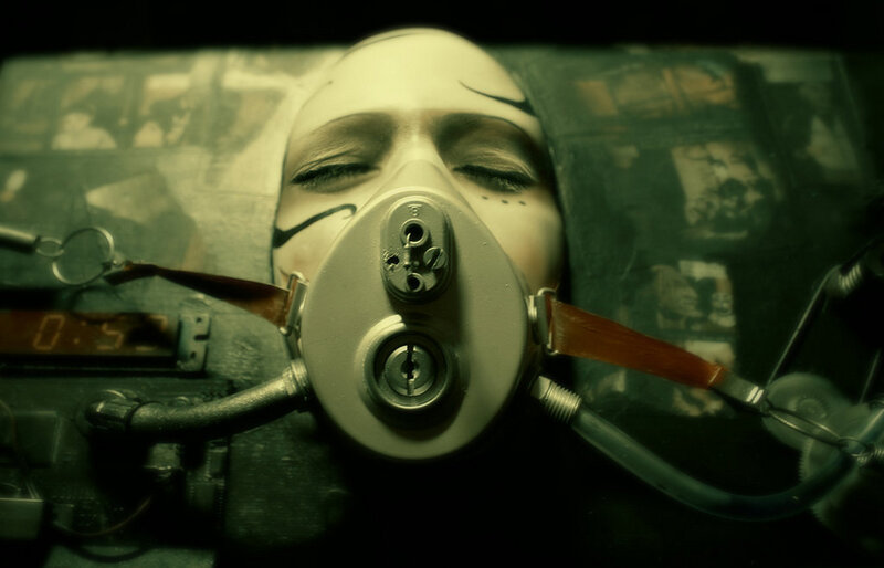 person with gas mask in dark room