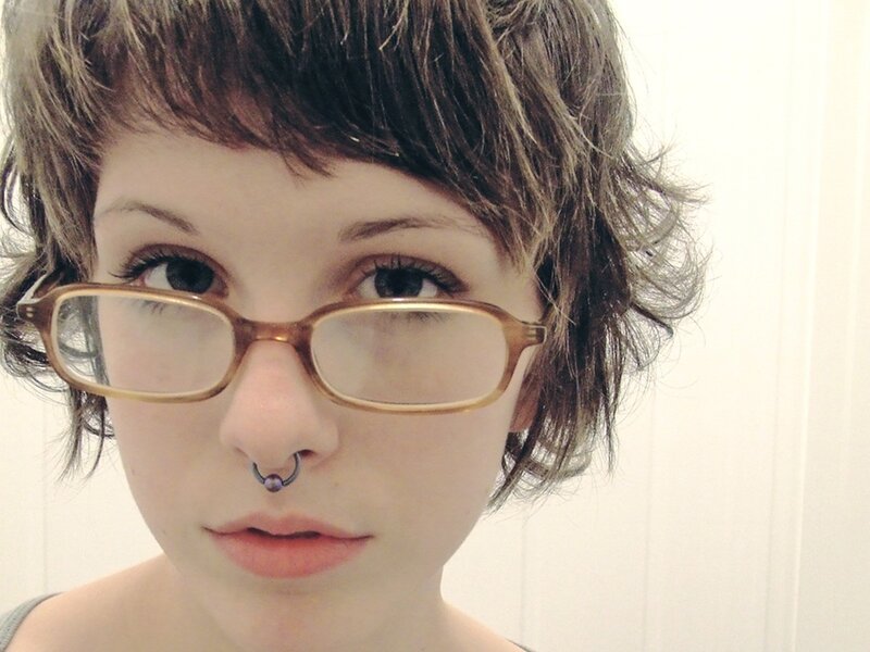 person with glasses and nose ring