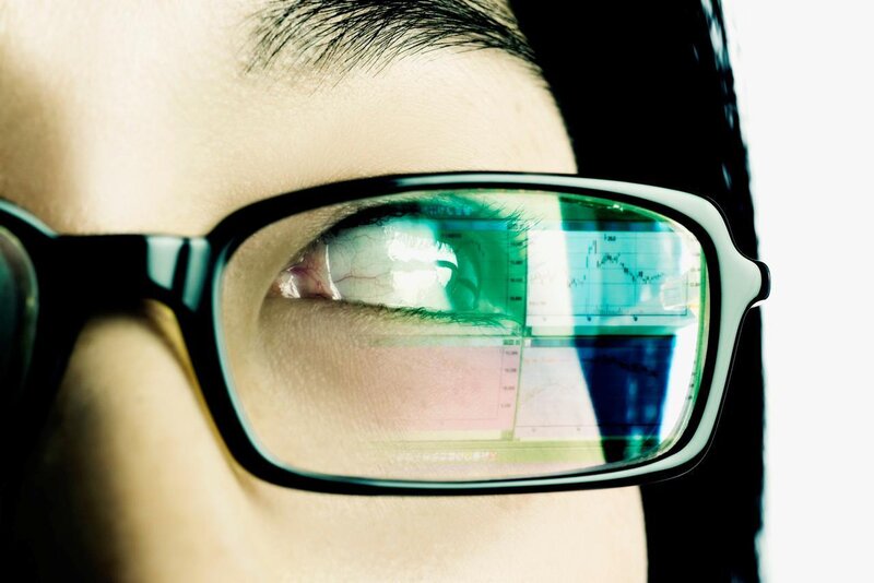 person with glasses reflecting charts
