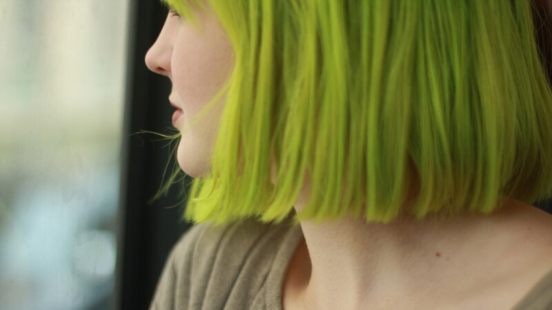 person with green hair in profile