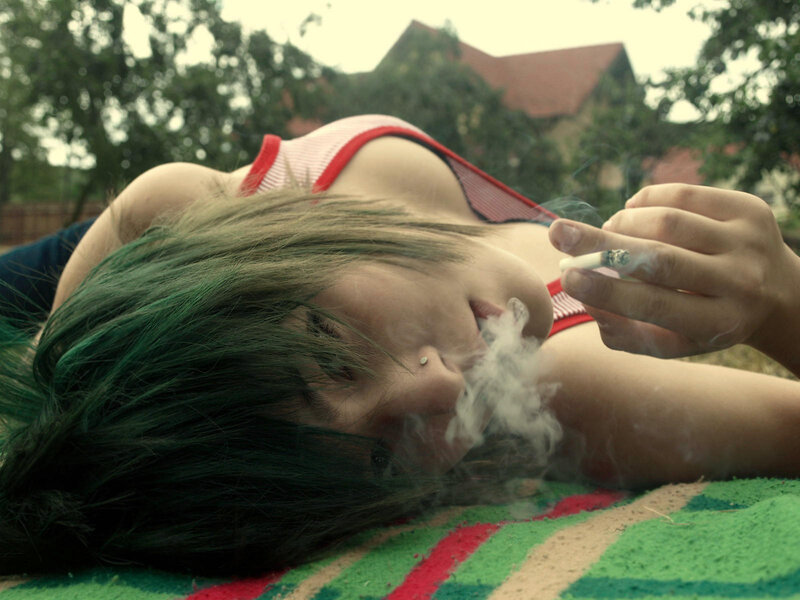 person with green hair smoking