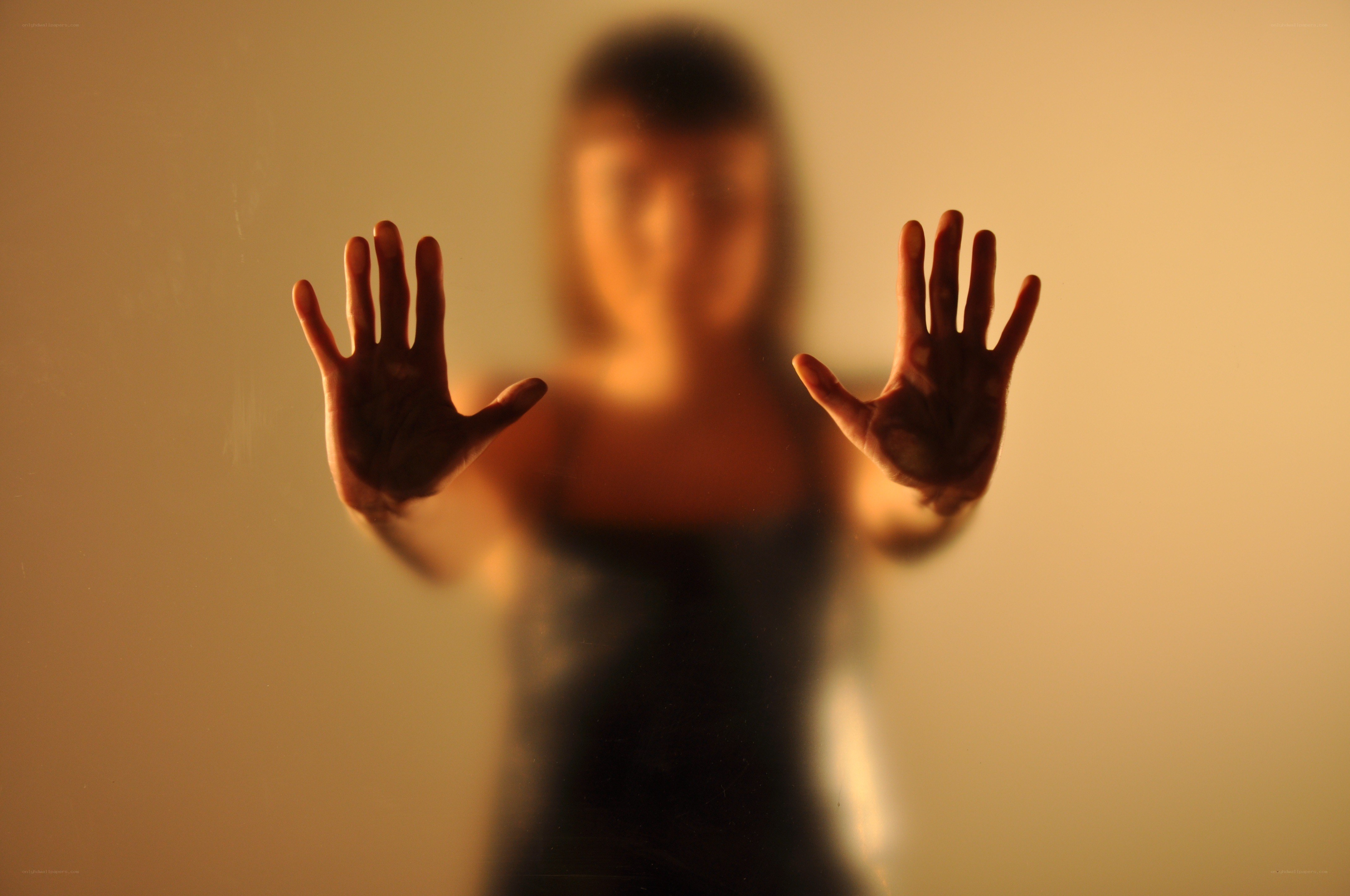 person with hands on glass