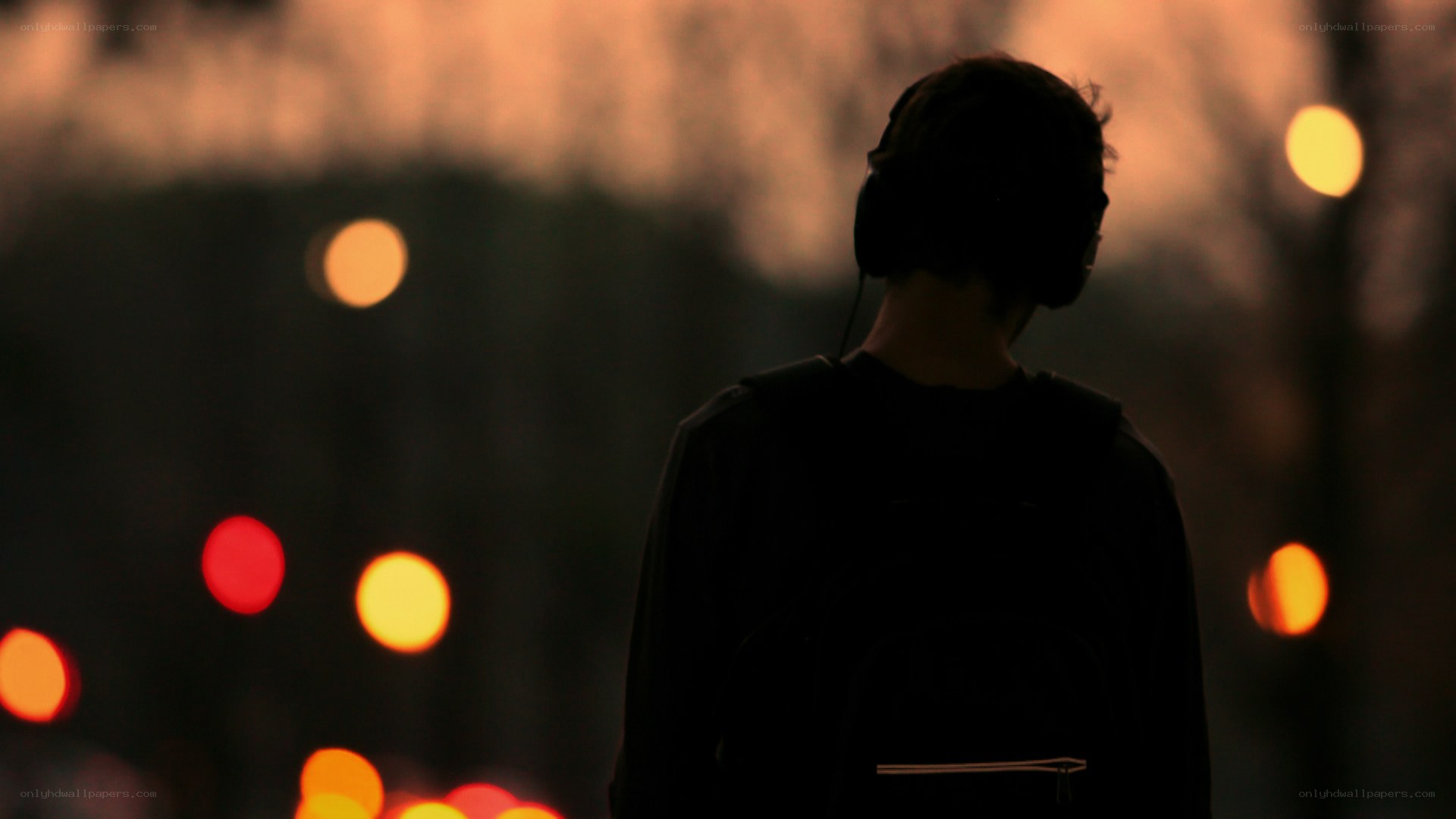 person with headphones at dusk